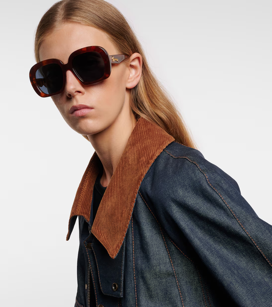 Modella che indossa gli occhiali da sole oversize Curvy di Loewe.